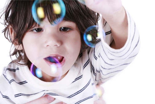 Toddler boy playing with bubbles